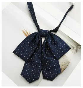 Detailed shot of dark blue Japanese JK uniform bow tie with white polka dots jacquard fabric.