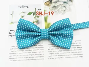 Detailed close-up view of a stylish turquoise bow tie featuring a classic white polka dots pattern.