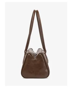 Detailed side view of a brown vintage shoulder bag, featuring structured design and dual handles.