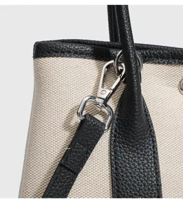 Borsa shopper in tela dettaglio della tracolla e ferramenta metallica primo piano qualità.