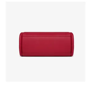 Detalle de bolso de cuero rojo con textura granulada premium y costuras de gran acabado.