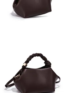 Dark brown leather women's shoulder bag detail, braided handle and metal hardware.