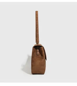 Side detail view of the vintage brown suede women underarm shoulder bag showing slim profile.