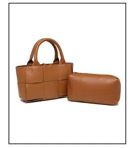 Vista detallada del bolso de mano de cuero tejido marrón con pochette y textura fina.