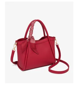 Vista detallada del bolso tipo cubo de cuero rojo con cinta, bolso de mujer versátil bandolera.