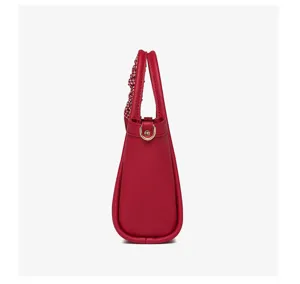 Bolso cubo de cuero rojo vista lateral, elegante bolso con asa de pañuelo y herrajes.