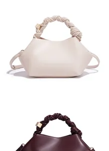 Close-up detail of the stylish leather handbag featuring a unique braided handle and metallic accent.