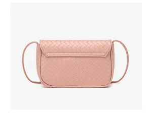 Detalle de bolso cruzado de cuero tejido rosa con textura trenzada y gran acabado.