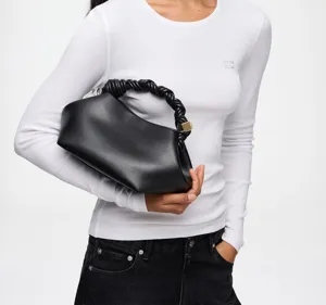 Elegantly crafted black leather handbag featuring a chic braided twist handle and sleek shell shape.