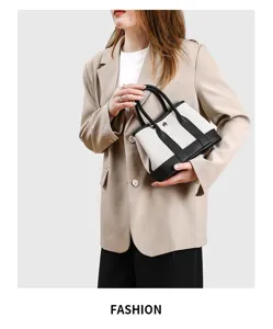 Dettaglio della piccola borsa in tela bicolore con manici in pelle e design elegante della tote.