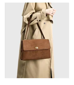 Detailed view of the vintage brown suede underarm bag showcasing texture and turn-lock closure.