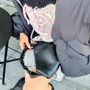 Stylish black leather handbag for women with braided handle, chic casual shoulder bag daily use.