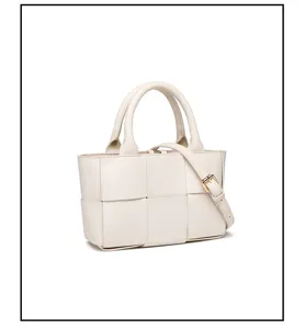 Detalle de bolso bandolera de cuero tejido blanco, mini bolso estructurado con asa.