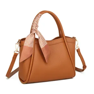 Elegante bolso bombonera de cuero marrón con pañuelo pata de gallo, bolso bandolera versátil.