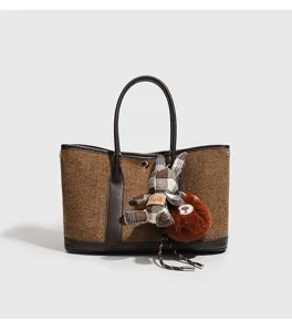 Gedetailleerd overzicht van tweed damesschoudertas met kleurmatching en schattige konijnenbedel.