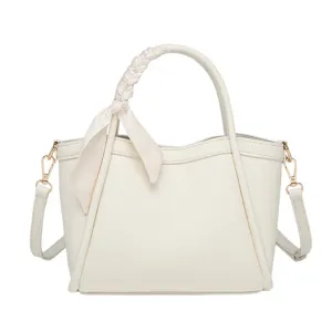 Elegante bolso bombonera de piel blanca con asa de pañuelo trenzado y correa cruzada mujer.