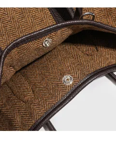 Gedetailleerd overzicht van een chique tweed tas met visgraatmotief en lederen afwerking.