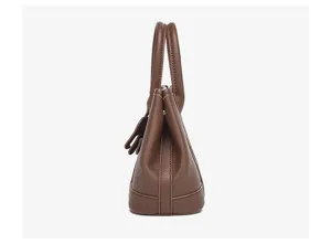 Side detail view of brown leather handbag featuring structured gusset and dual handles.