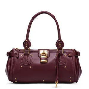 Borsa Boston in pelle bordeaux, dettaglio con lucchetto dorato e decorazioni con rivetti.