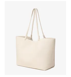 Minimalistische gebroken witte PU lederen shopper tas detail met slanke dubbele bandjes.