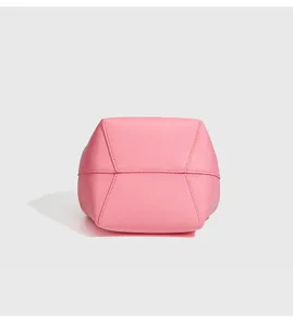 Detaillierte Unteransicht der rosa Leder Mini Eimer Tasche mit feinen Nähten und Struktur.