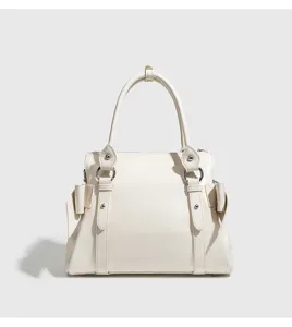 Detailed close-up shot of the white fashion bow handbag featuring metallic rings and leather texture.