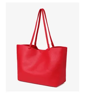 Detail van rode PU lederen shopper, grote schoudertas textuur en dubbele riem design.
