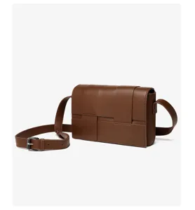 Braune gewebte Leder Umhängetasche Detailansicht mit verstellbarem Gurt und Metallschnalle.