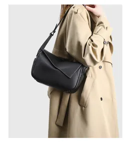 Vista dettagliata della borsa a tracolla elegante in pelle nera con patta piegata unica.