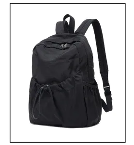 Black nylon backpack detail showcasing front drawstring pocket and durable shoulder straps.