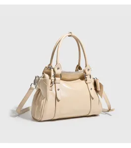Beige leather shoulder bag detail with cute side bows, dual top handles and metal parts.