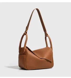 Borsa a spalla in pelle marrone con design a patta piegata unica e spallacci annodati eleganti.