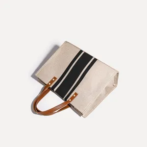 Minimalistische Segeltuchtasche mit schwarzen Streifen und braunen Griffen, Alltagstasche.