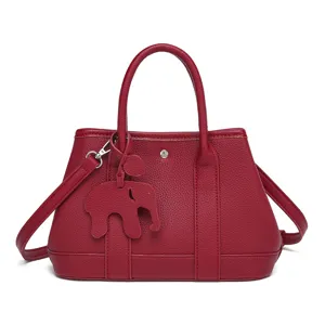 Red leather tote bag, versatile casual shoulder handbag with cute elephant charm for women.