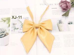 Yellow JK uniform bow tie, glossy fabric flat lay detail view with sharp corner design.