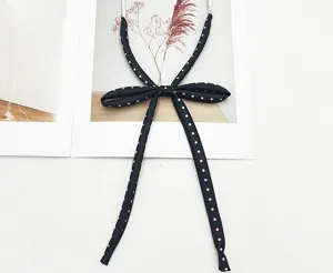 Gros plan détaillé du ruban de col d'uniforme JK noir et rose à pois avec nœud papillon.
