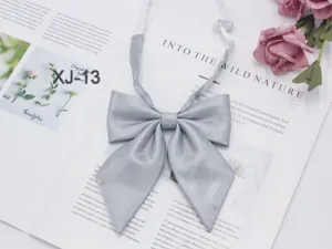 Close-up detail of the grey sparkling JK bow tie, featuring sharp corner design for school uniforms.