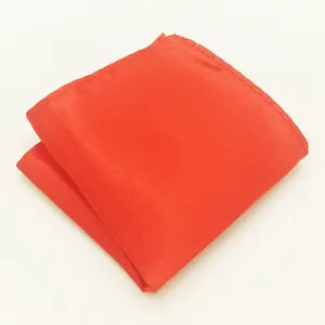 Gedetailleerde close-up van de helderoranje polyesternylon zakdoek netjes opgevouwen.