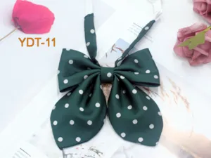 Detailed view of the dark green polka dot bow tie with white spots, cute JK accessory.