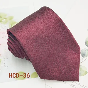 Detailed view of wine red men's necktie, elegant jacquard fabric for wedding and formal wear.
