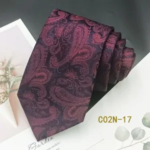 Detail view of burgundy men's tie with elegant paisley jacquard pattern, fine texture.