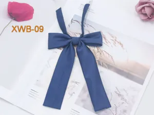 Detail shot of navy blue twill JK uniform bow tie, featuring elegant long ribbon straps.