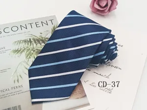 Detailed view of the dark blue striped tie, showing premium fabric texture and fine stitching.