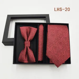 Vista detallada del elegante conjunto de corbata, pajarita y pañuelo rojo con motivos.