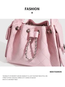 Detailed view of pink quilted leather bucket shoulder bag featuring chic chain strap and pockets.