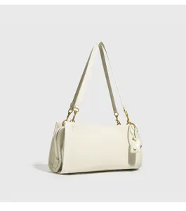 Detalles en primer plano del bolso de hombro blanco con herrajes dorados y cremallera elegante.