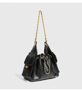 Black quilted leather bucket shoulder bag with gold chain strap and elegant commuter style.