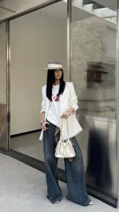 Detail shot of women's white quilted chain bucket shoulder bag with elegant commuter fashion style.
