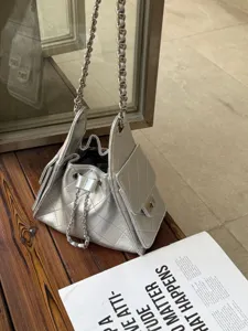 Detailed view of the luxury silver quilted shoulder bag with metallic chain and clasp.
