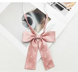 Close-up pink polka dot JK bowtie detail, cute Japanese style neck ribbon accessory.